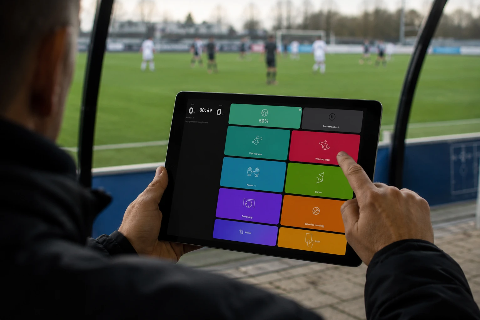 Coach registreert een actie op de tablet vanuit de dugout